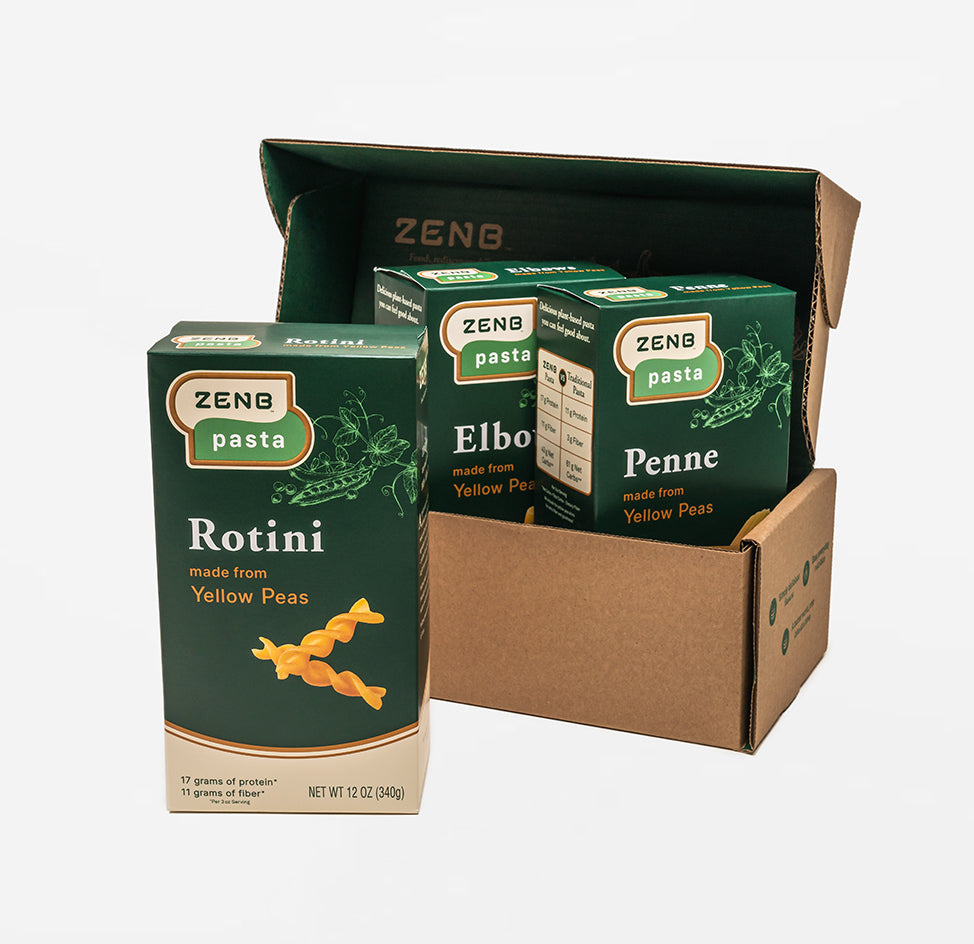 A shipping box with three boxes of ZENB Pasta. A box of Rotini is outside the shippig box, and a box of Elbows and a box of Penne are inside the shipping box.